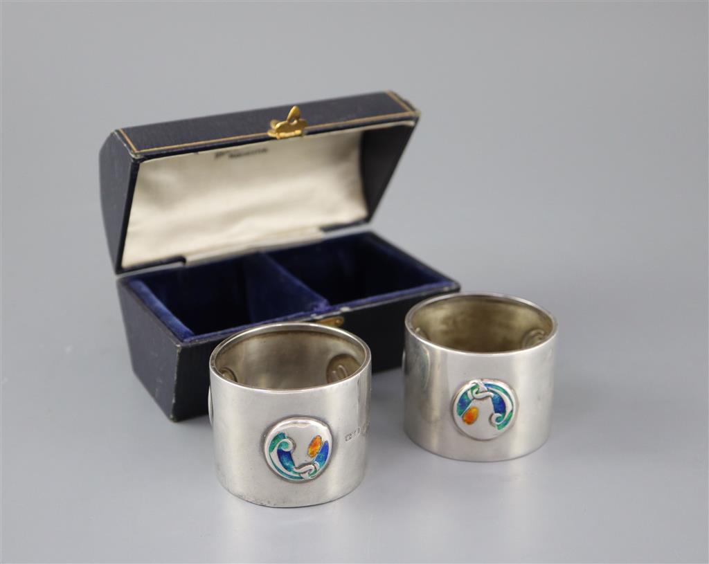 A cased pair of Edwardian Art Nouveau silver and enamel napkin rings, by William Hair Haseler,